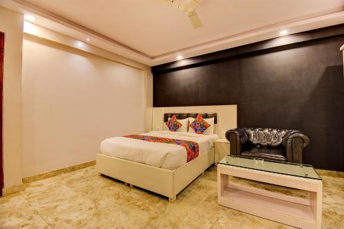 - une chambre avec un lit et une chaise dans l'établissement FabHotel SRK Platinum Inn, à Bangalore