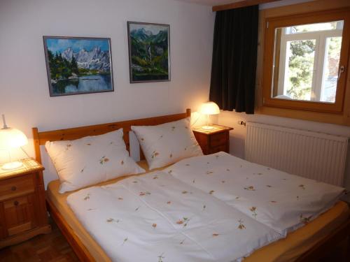 a bedroom with a bed with two lamps and a window at Haus Gradwohl in Schladming
