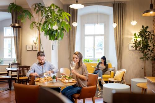 a group of people sitting at a table in a restaurant at JUFA Hotel Judenburg - Self Check-In in Judenburg