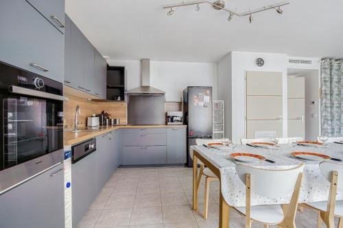 une cuisine avec une table et des chaises ainsi qu'une cuisine avec des produits nucléaires dans l'établissement Vacances pour 10 personnes tout à pied !, à Saint-Jean-de-Monts