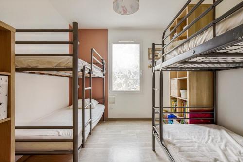 une chambre avec trois lits superposés et une fenêtre dans l'établissement Vacances pour 10 personnes tout à pied !, à Saint-Jean-de-Monts