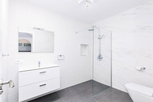 baño blanco con ducha y lavamanos en Summer House, Golf del Sur, en San Miguel de Abona