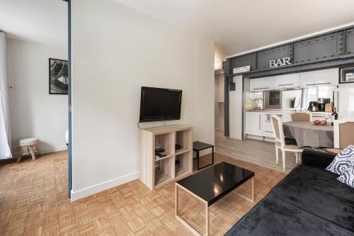 ein Wohnzimmer mit einem Sofa und einem TV in der Unterkunft Apart of Paris - Chatelet - Rue de Rivoli in Paris