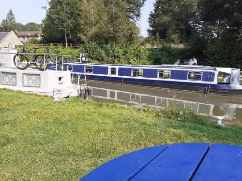 a blue and white boat on a river at The Barge Inn in Bradford on Avon