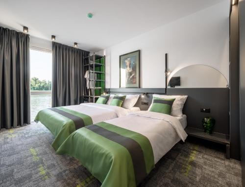 two beds in a hotel room with green and white at Joy 5 Hotel & SPA in Belgrade