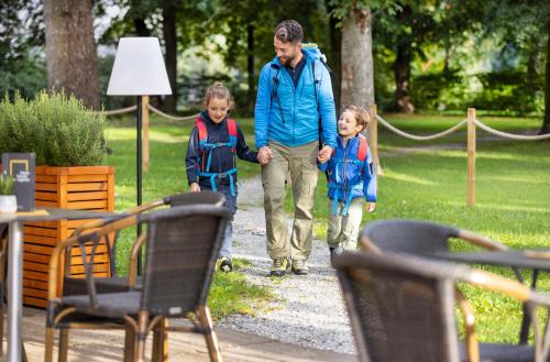 a man and two children walking down a path at JUFA Hotel Judenburg - Self Check-In in Judenburg
