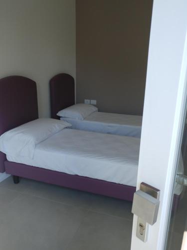 two beds are in a room with a window at SALAPIA SALIS RESORT in Margherita di Savoia
