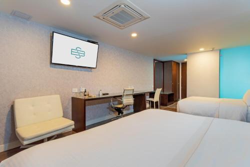 a hotel room with a bed and a tv at Hotel Santa Barbara Boutique in Bogotá