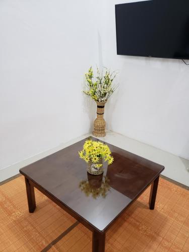 una mesa de café con un jarrón de flores. en Brand new vacation house- Private gated community en Banda Aceh