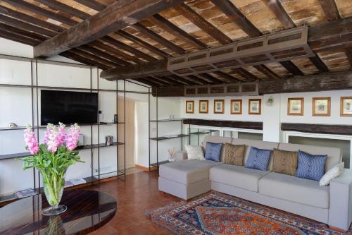 a living room with a white couch and a vase of flowers at Babuino 79 in Rome