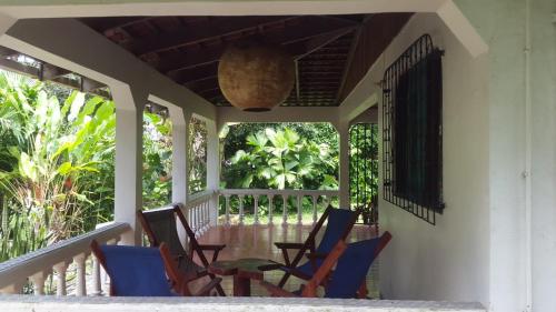 a porch with chairs and a table on it at Hostal Cecilia in Puerto Viejo