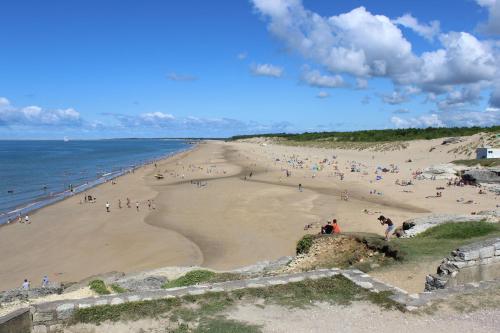 a group of people on a beach near the ocean at Camping Le Puits de l'Auture in Saint-Palais-sur-Mer
