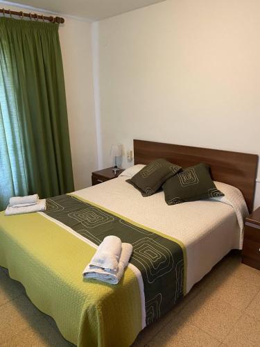 um quarto com uma cama grande e cortinas verdes em Hostatgeria i Restaurant Coll de Condreu em Les Planes d'Hostoles