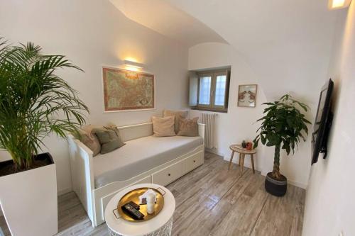 un salon avec un canapé blanc et des plantes dans l'établissement Casa Meraki - Apartment, à Bergame