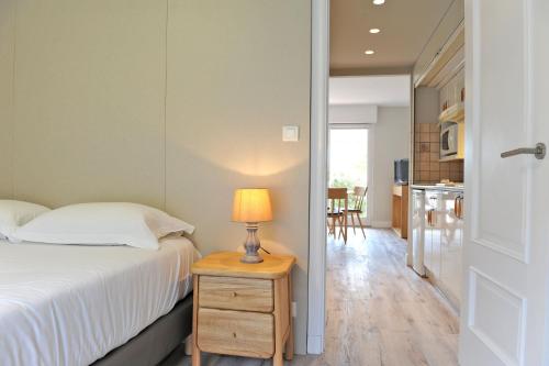 a bedroom with a bed and a table with a lamp at Hotel & Appartements Gochoki in Bidart