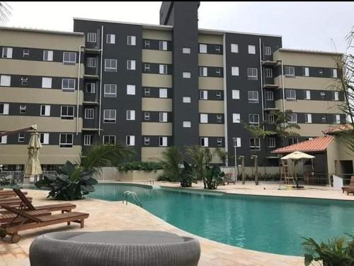 um grande edifício de apartamentos com uma grande piscina em Jardim das Palmeiras II Home Resort JP2 Ubatuba - Apartamento com 2 Dorms, 1 Suíte, Churrasqueira Gourmet, Piscina Adulto e Infantil, Jacuzzi Aquecida, Sauna, Academia, Salão de Jogos e Playground em Ubatuba