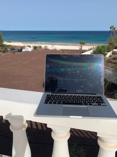a laptop computer sitting on a table near the beach at Welooveyou Top Fortuny in Costa Calma