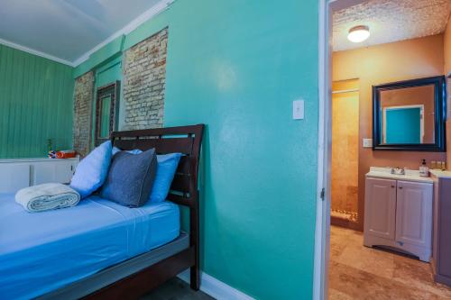 a bedroom with blue walls and a bed with blue pillows at Victoria House in Frederiksted