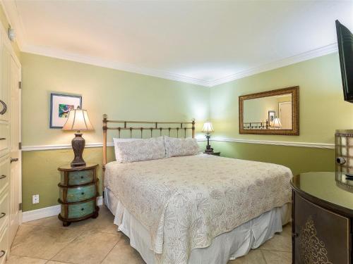 1 dormitorio con cama y espejo en la pared en South Seas Beach Villa 2313, en Captiva