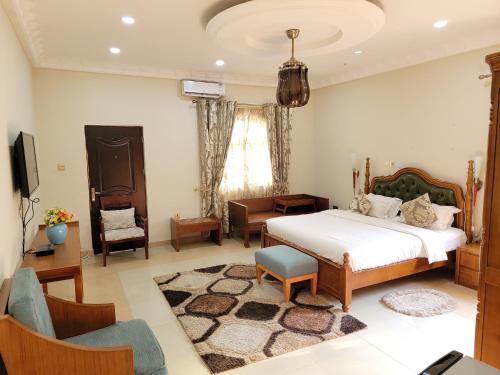 アクラにあるAfri-Royal Hotelのベッドルーム(ベッド1台、椅子、テレビ付)