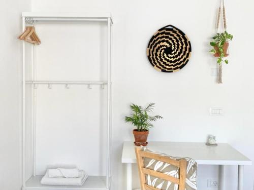 a white dining room with a table and a chair at Pathos Guest House in Quarto dʼAltino