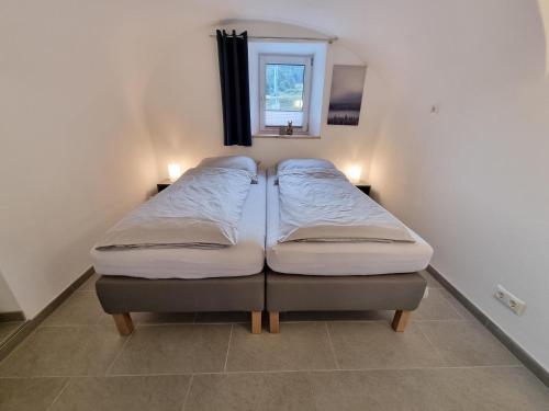 2 Einzelbetten in einem Zimmer mit Fenster in der Unterkunft wohnung-nummer-2 in Pielenhofen