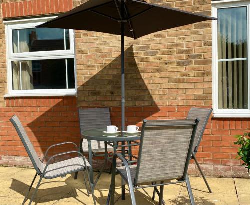 a table with two chairs and an umbrella at Aylesbury Contractor & Staycation Home in Aylesbury