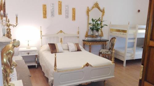 a bedroom with a white bed and two bunk beds at Império Romano Guest House in Beja
