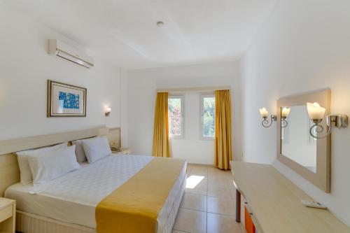 um quarto com uma cama grande e um espelho em Natur Garden Hotel em Bitez