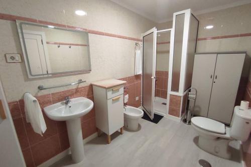ein Bad mit einem Waschbecken, einem WC und einer Dusche in der Unterkunft Apartamento Boutique Cruce de Melenara in Melenara