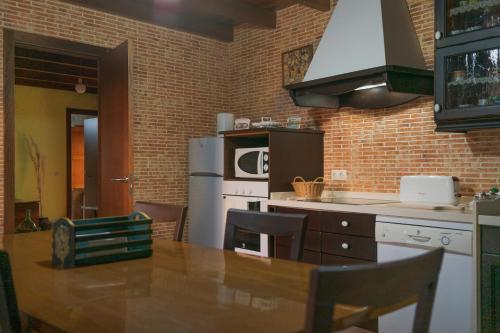 eine Küche mit einem Holztisch und einem Kühlschrank in der Unterkunft A Casa da Charca - Casa rural con jardín in Pontevedra