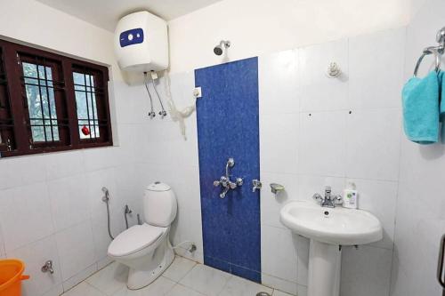 a bathroom with a toilet and a sink at Dalhousie Luxury Villa in Nainital