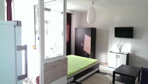 コンスタンツァにあるスタジオ ニクの小さなベッドルーム(緑のベッド1台、テーブル付)