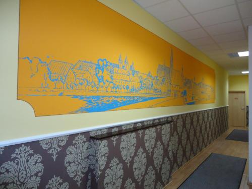 a hallway with a mural of a city on the wall at Stadthotel Regensburg in Regensburg