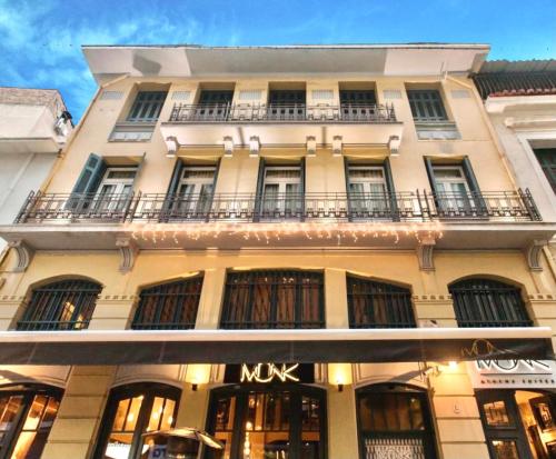un gran edificio blanco con un letrero de mux en MONK Monastiraki Suites with Rooftop Bar, en Atenas