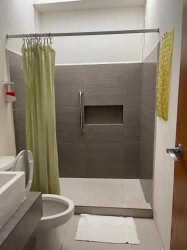 a bathroom with a shower curtain and a toilet at Hotel Villa Escondida Campeche in Campeche