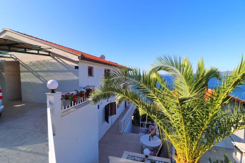 a balcony of a building with a palm tree at Seaside Apartments Hrkać in Orebić