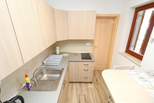 a small kitchen with a sink and a counter at Seaside Apartments Hrkać in Orebić