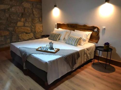 a bedroom with a large bed with a tray on it at Quinta do Pinheiro in Guimarães