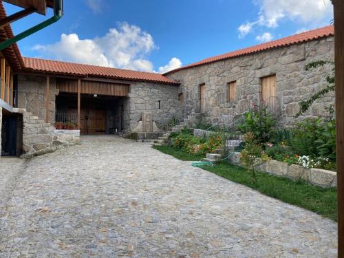 an external view of a stone building with a driveway at Quinta do Pinheiro in Guimarães