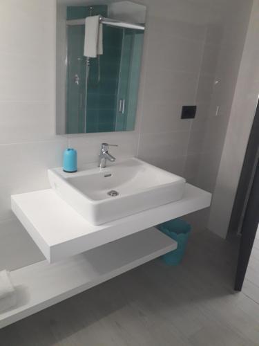 a white bathroom with a sink and a mirror at IsolaDino b&b sweet home in Praia a Mare