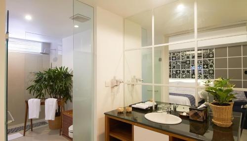 a bathroom with a sink and a mirror at The Kanjeng Suites & Villas Sanur in Sanur