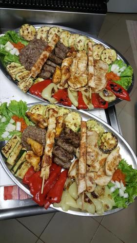 dos platos de comida con diferentes carnes y hortalizas en bungalo en Buzet