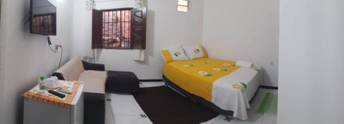 Habitación pequeña con cama y sofá en Residência dos Félix, en Morro de São Paulo