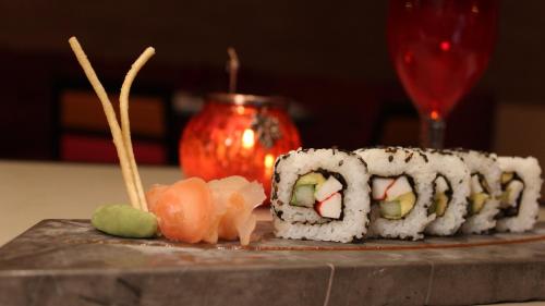 a plate of sushi on a table with a glass at Fiesta Americana Puerto Vallarta All Inclusive & Spa in Puerto Vallarta