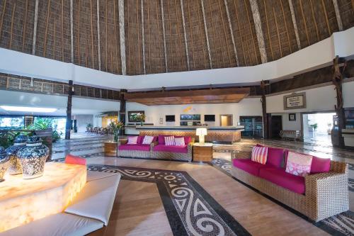 a lobby with pink couches and a bar at Fiesta Americana Puerto Vallarta All Inclusive & Spa in Puerto Vallarta