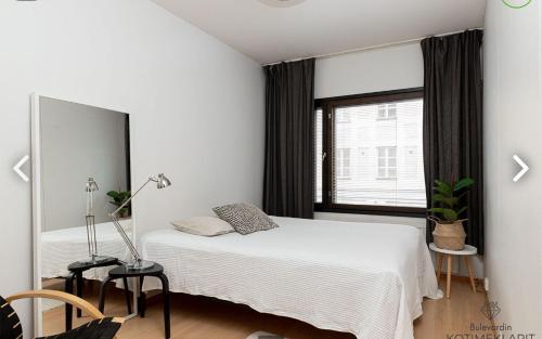 um quarto com 2 camas e uma grande janela em Scandinavian Home in heart of Helsinki 26 em Helsinque