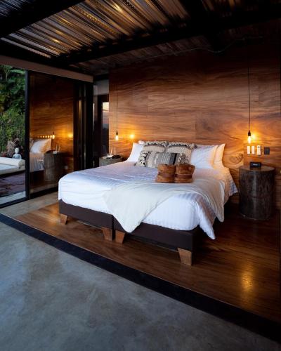 a bedroom with a large bed with a wooden wall at Bio Habitat Hotel in Armenia