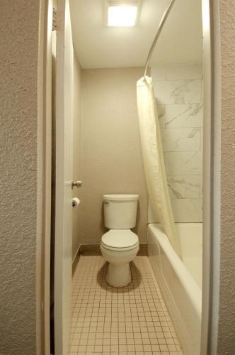 a bathroom with a toilet and a shower and a sink at Town and Country INN in Rogers