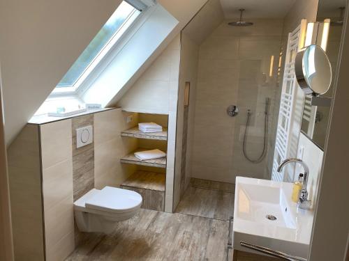 een badkamer met een toilet, een wastafel en een dakraam bij Ferienwohnung Olli Koch in Reken